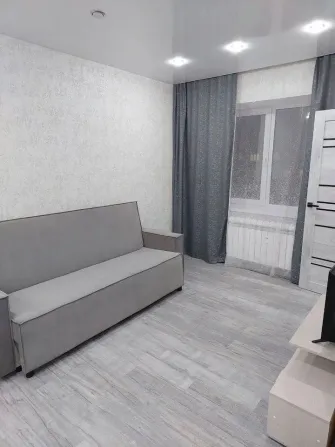 Гостинаядағы диванымен және үлкен терезелерімен кеңістік