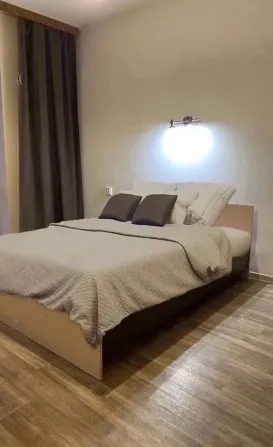 Екі адамдық төсегі және үстінде жарығы бар жат bedroom