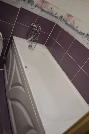 Ванна бөлмесі ванна және унитазбен, күлгін реңктерде безендірілген