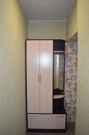 Коридор айна мен киім шкафымен түрлі-түсті қабырға қағаздарының фонында