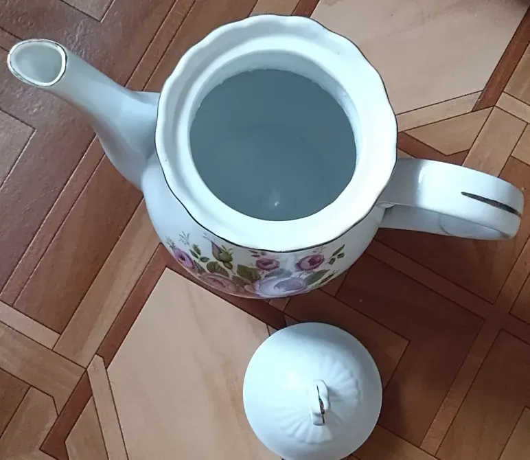 Открытый чайник с крышкой на поверхности