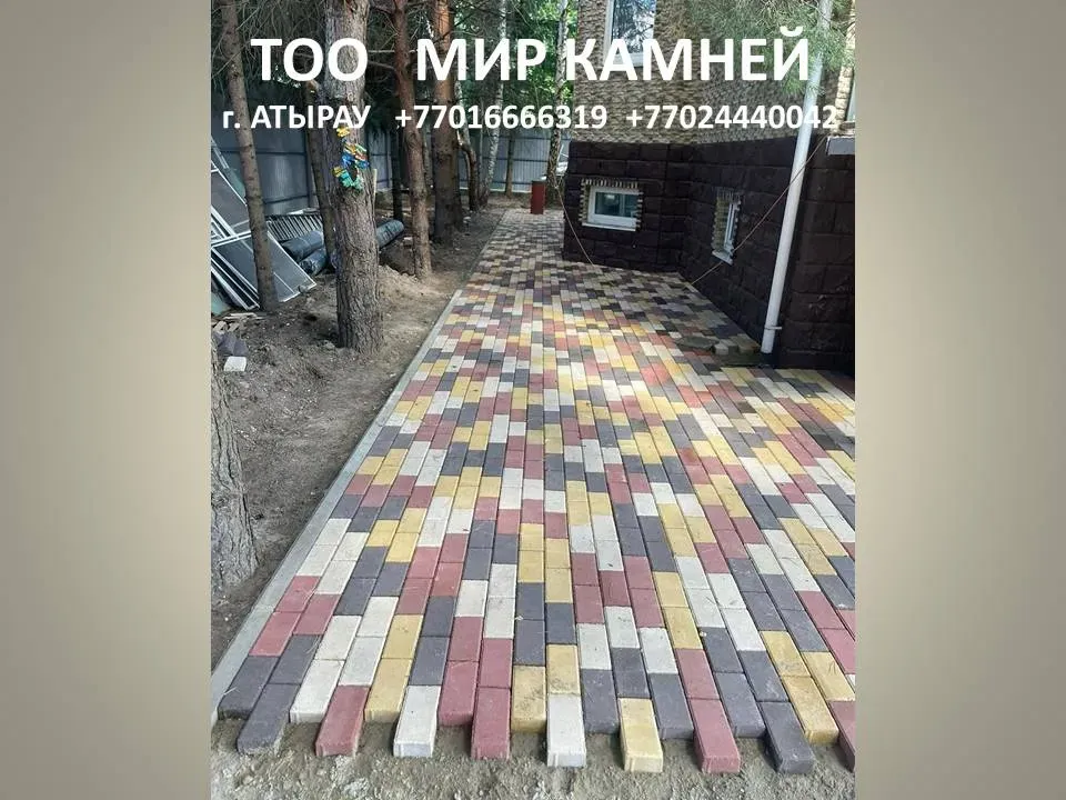 Ағаштардың фонында түрлі-түсті тротуарлық плиткамен жабылған жол