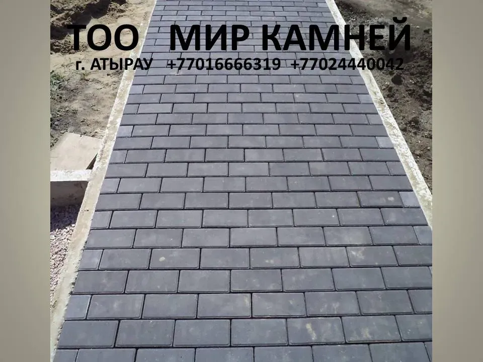 Құрылыс жұмыстар арасында орналасқан жолдағы қара түсті тротуарлық плитка.