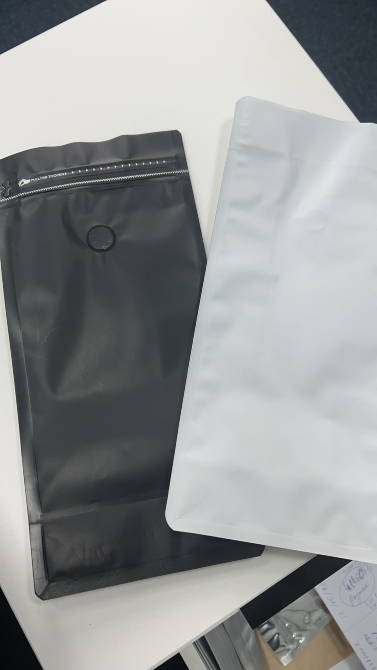 Стол үстінде екі пакет: біреуі қара, екіншісі ақ, үстінде застежкасы бар