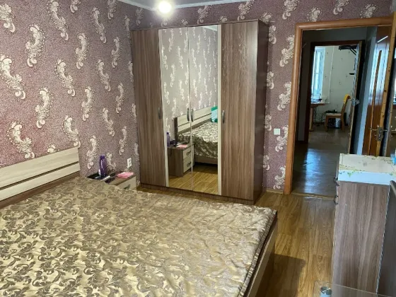Спальня с зеркальным шкафом и современной отделкой