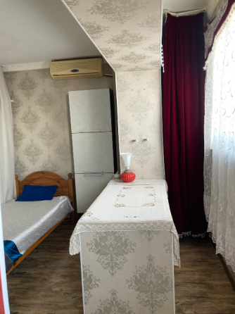 Уютная спальня с кроватью и шкафом. Красивые обои и светлое окно