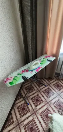Доска для глажки тканей в углу комнаты