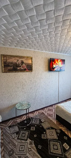 Современный интерьер спальни с телевизором и картиной на стене