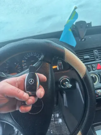 Ключи от автомобиля Mercedes-Benz, один с логотипом и кнопками, другой без значков