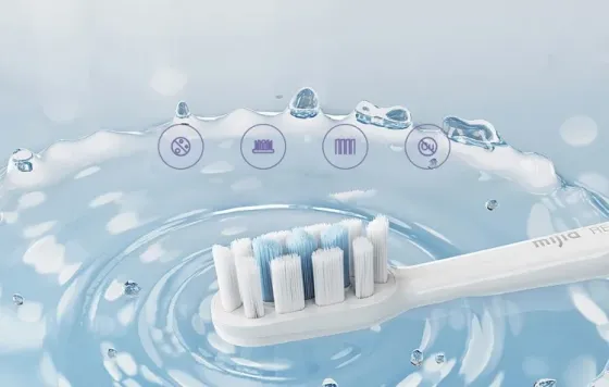 Близкий план щетины зубной щетки с каплями воды на фоне