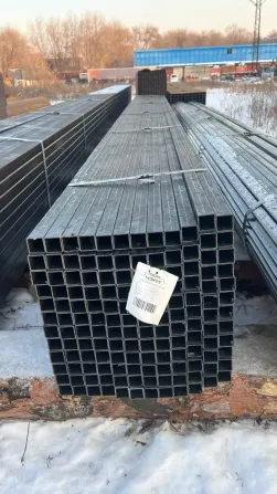 Металлические квадратные трубы, упакованные и накрытые на стройплощадке