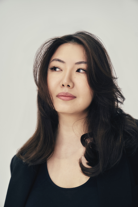 Ұзын шашы мен стильді киімі бар әйелдің портреті, алыста қарап тұрған