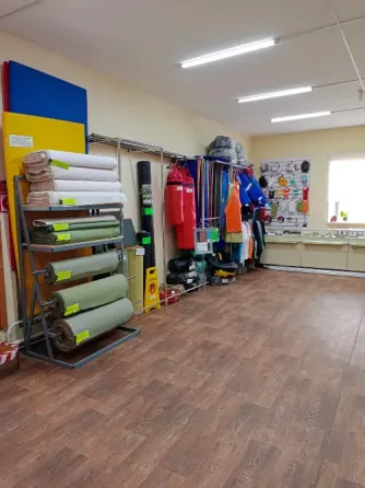 Уголок магазина с рулонами тканей и одеждой, связанной с outdoor-активностями
