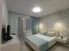 Заманауи жатын бөлмесі ақ төсекпен һәм жұмсақ жарықпен