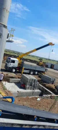 Гусеничный кран работает на строительной площадке среди бетонных блоков