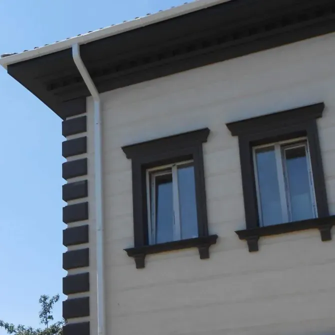 Угол дома с яркими окнами и контрастной отделкой