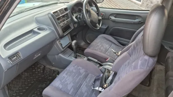 Внутренний вид передних сидений старинного внедорожника Toyota, показаны передние кресла и консоль