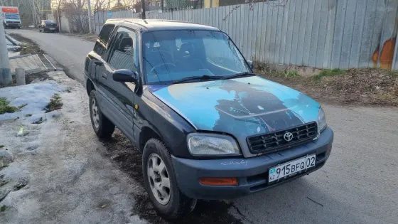 Старинный внедорожник Toyota с яркой графикой на капоте, припаркованный на улице
