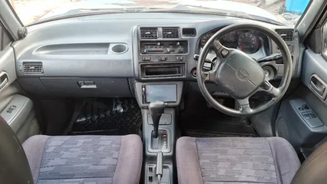 Интерьер старинного внедорожника Toyota с ручной коробкой и множеством органов управления