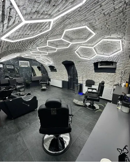 Эстетикалық барбершоп қыштан жасалған қабырғалар мен стильді жарықтандырумен
