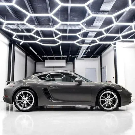 Серый спортивный автомобиль с элегантным дизайном на фоне стильного интерьера