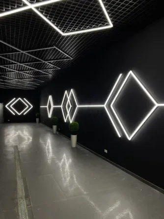 Современный интерьер с геометрическим LED-освещением на черной стене
