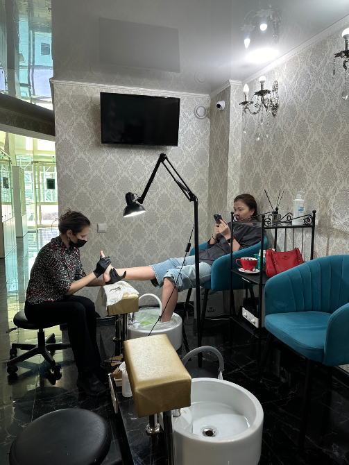 Процесс педикюра с мастером и клиентом в салоне красоты