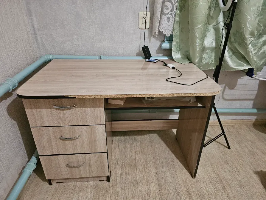 Үш жәшігі бар және тегіс беті бар үстел, бөлмеде орналасқан