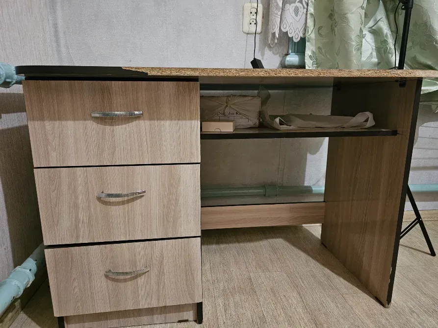 Жерге орнатылған жәшіктер мен сөресі бар үстелдің көрінісі