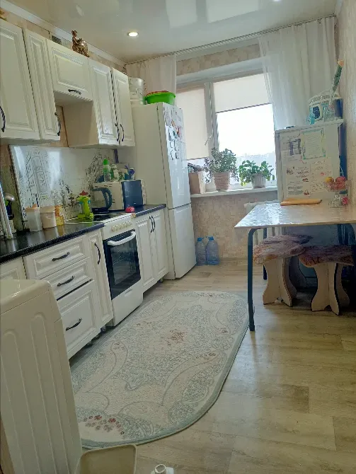 Кухня с белыми шкафами и бытовой техникой