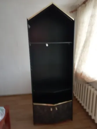 Чёрный угловой шкаф с золотыми деталями в светлой комнате