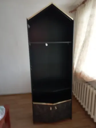 Чёрный угловой шкаф с золотыми деталями в светлой комнате
