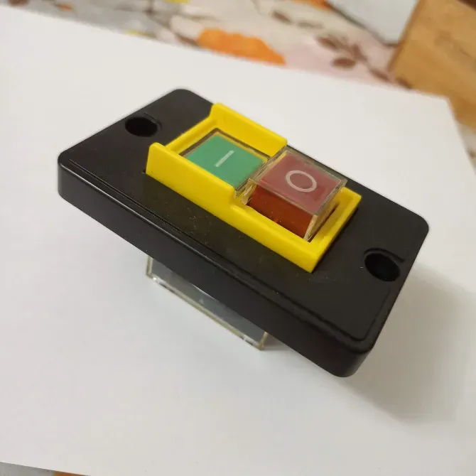 Кнопка с зеленым и оранжевым переключателями на черном корпусе