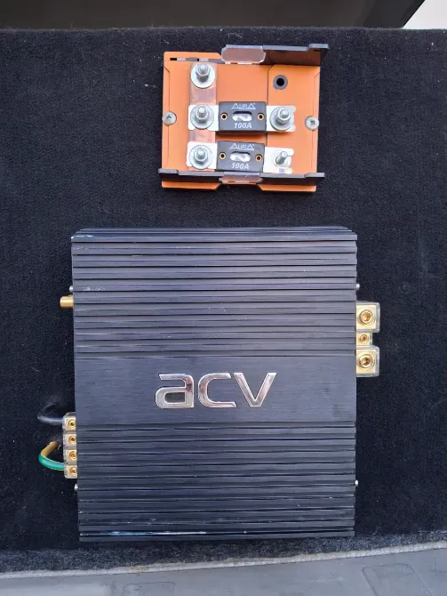 Усилитель ACV, установленный в багажнике автомобиля, с видимыми соединениями