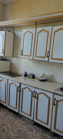 Кухня с белыми шкафами и столом