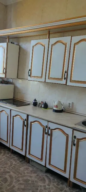 Ақ шкафтар мен үстелі бар асхана