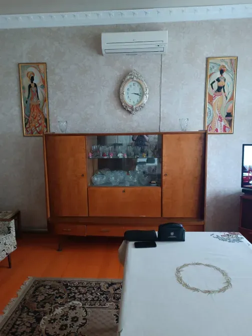 Часть спальни с деревянным шкафом и картинами на стенах