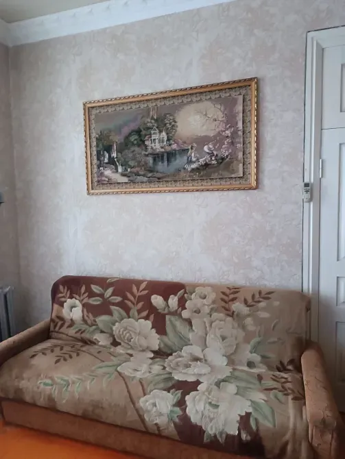 Диван с цветочным узором на фоне картины