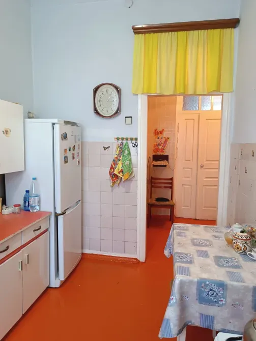 Кухня с холодильником и часами, оранжевый пол