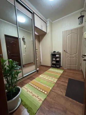 Айна шкафы және жасыл кілемшесі бар коридор