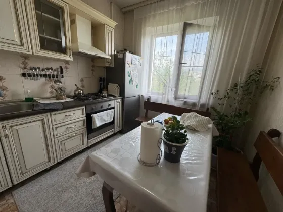 Ас үй гарнитурымен және асхана үстеліне ие, терезелері көшеге қарай шығатын