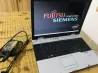 Fujitsu Siemens ноутбугінің қосылған экраны логотип фонында, қуат блогымен қосылған.