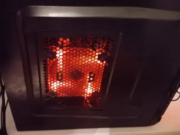 Внутренний вид компьютерного корпуса с видимой подсветкой вентилятора и сетчатой панелью