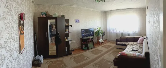 Современный интерьер комнаты с телевизором и диваном, светлые стены и окно