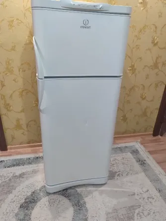Холодильник Indesit на фоне обоев с цветочным узором