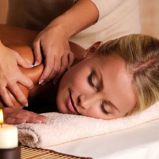 Молодая женщина в джинсовом жилете и белой футболке позирует на фоне интерьера