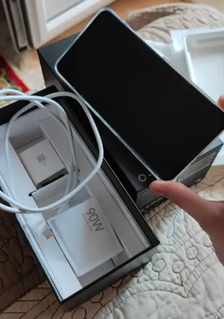 Xiaomi 15 Ultra смартфонының қолда аксессуарлармен қораптың үстінде