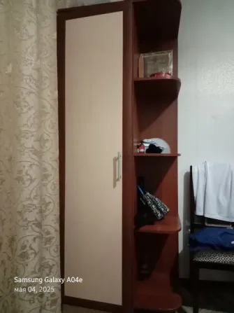 Шкаф с полками и одеждой в комнате