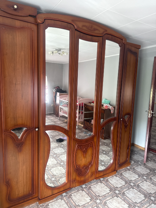 Деревянный шкаф с зеркалами в интерьере комнаты