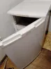 Ашық есігі бар тоңазытқыш, бөлменің бұрышында орналасқан